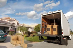 Moving truck parked outside a suburban home with boxes