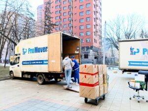Movers loading boxes into ProMovers trucks during an urban relocation