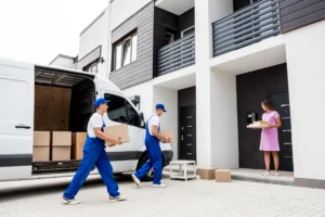 Movers delivering boxes to a woman at her home