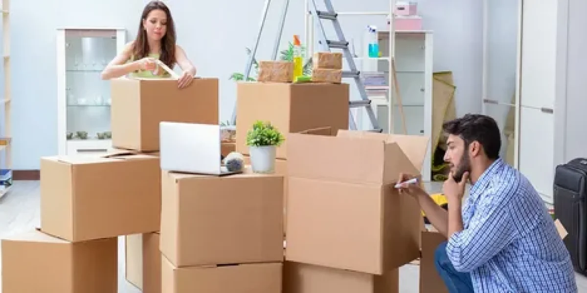 Couple labeling and sealing cardboard boxes while preparing for a move