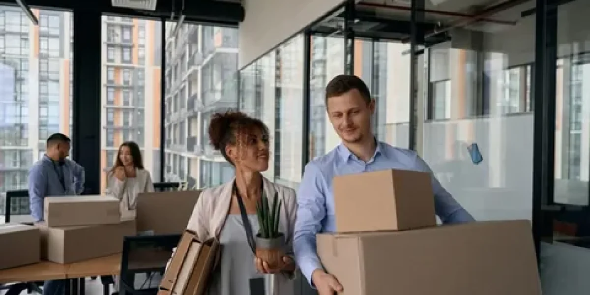 Employees carrying boxes during an office move.