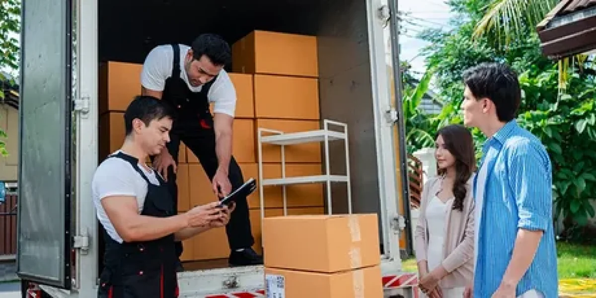 Movers checking a delivery list with customers beside a moving truck.